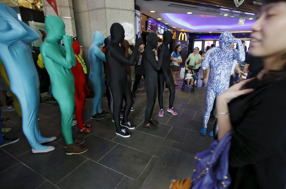 Participants wearing Zentai costumes take part in a march down the shopping district of Orchard Road during Zentai Art Festival in Singapore