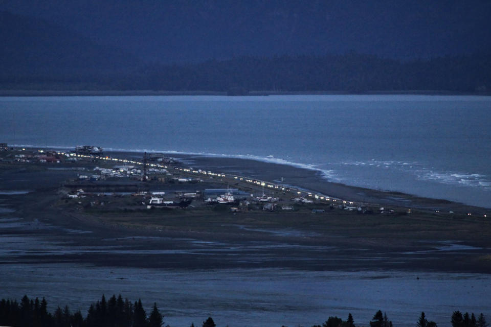 Headlights from a line of cars shine at dusk as people evacuate the Spit in Homer, Alaska, following a powerful earthquake in the Aleutian Islands that prompted a tsunami warning. There were no immediate reports of damage in the sparsely populated area of the state, and the tsunami warning was later canceled. (Pat Williams Russell via AP)