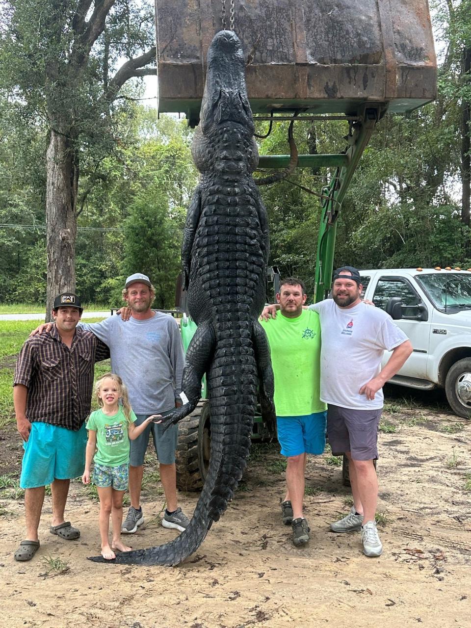 (From left) Josh Williams, Jarrod Davis, Kyle Mallett and Matthew Brooks pose with a 13-foot, 3-inch alligator they caught during the 2023 alligator season. Also pictured is Davis' daughter, Eva, 5.