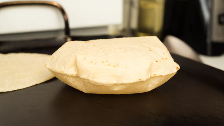 Corn tortilla cooking on comal