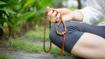 Malas sind Meditationsketten mit 108 Perlen und einem "Guru". Während einer Meditation kann Perle für Perle beispielsweise dasselbe Mantra wiederholt werden. 108 ist eine wichtige Zahl im Yoga. So werden nicht nur Mantren so oft wiederholt, sondern zum Beispiel auch Sonnengrüße. Es gibt verschiedene Erklärungen für die 108. Eine ist: Das Alphabet der alten, indischen Sprache Sanskrit besteht aus je 54 männlichen und weiblichen Buchstaben. (Bild: iStock / MangoStar_Studio)