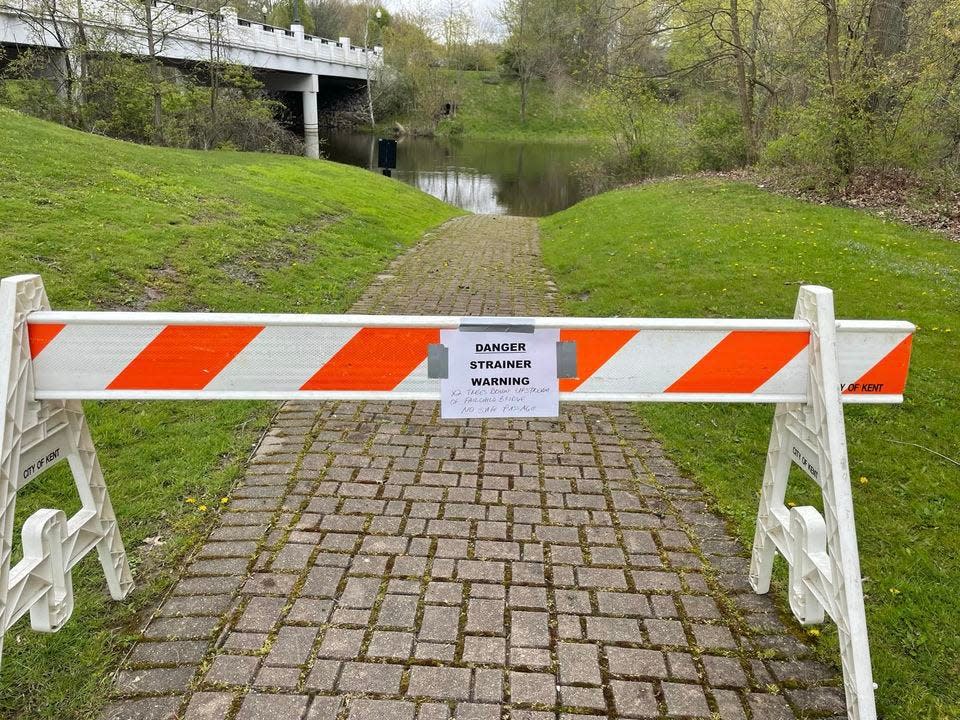 Warnings were placed upriver from where two downed trees are creating a hazard on the Cuyahoga River, north of Fairchild Avenue, in Kent on Friday.