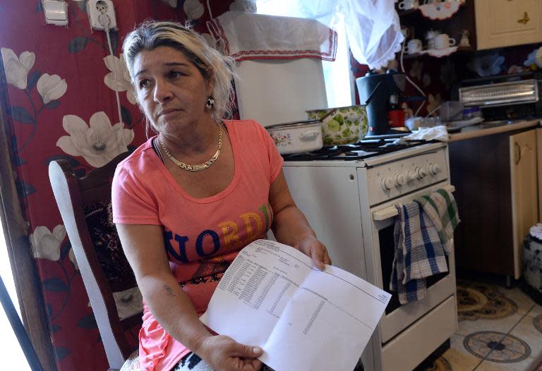 Eva Molnar show's the family's zero debit invoice in the kitchen of her home in the Roma quarter in Miskolc, Hungary on October 6, 2014