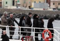 Relatives of the 32 victims of the Costa Concordia shipwreck, aboard a ferry approach the ship off the Tuscan Island Isola del Giglio, Italy, Sunday, Jan. 13, 2013. Survivors of the Costa Concordia shipwreck and relatives of the 32 people who died marked the first anniversary of the grounding Sunday. The first event of Sunday's daylong commemoration was the return to the sea of part of the massive rock that tore into the hull of the 112,000-ton ocean liner on Jan. 13, 2012 and remained embedded as the vessel capsized along with its 4,200 passengers and crew. (AP Photo/Gregorio Borgia)