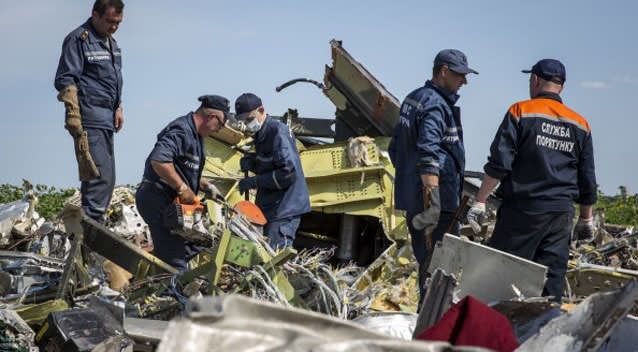 Ukrainian rescue servicemen inspect part of the wreckage of Malaysia Airlines flight MH17. Photo: Rob Stothard/Getty