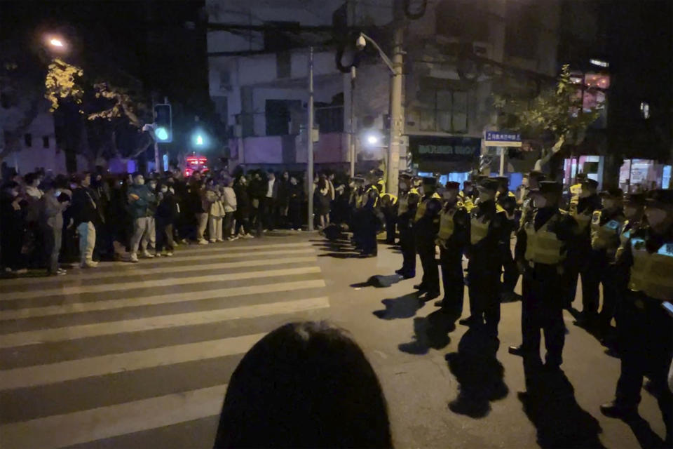 FILE - Chinese police officers block off access to a site where protesters had gathered in Shanghai on Nov. 27, 2022. What started as an unplanned vigil last weekend in Shanghai by fewer than a dozen people grew hours later into a rowdy crowd of hundreds. The protesters expressed anger over China's harsh COVID-19 policies that they believed played a role in a deadly fire on Nov. 24 in a city in the far west. (AP Photo, File)