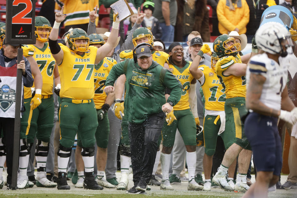 North Dakota State guard Brandon Westberg (77) and other players celebrate after head coach Matt Entz runs away after he was doused during the final moments of the FCS Championship NCAA college football game against Montana State, Saturday, Jan. 8, 2022, in Frisco, Texas. (AP Photo/Michael Ainsworth)