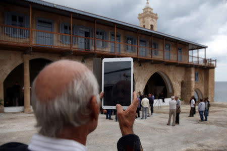 A pilgrim takes pictures of the Church of the Monastery of Apostolos Andreas in north-eastern Cyprus after the structure was reopened after two years of renovation, Cyprus November 7, 2016. REUTERS/Yiannis Kourtoglou