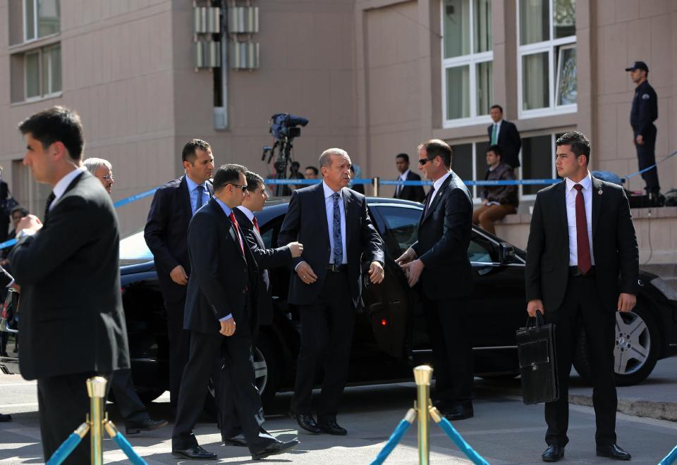 Turkish Prime Minister Recep Tayyip Erdogan, center, is surrounded by his security members outside his office in Ankara, Turkey, Thursday, April 17, 2014. Turkey's parliament looks set to pass a bill that increases the powers and immunities of the country's spy agency. It is the latest in a string of moves critics say is undermining democracy in the country that is a candidate to join the European Union. The bill, expected to be voted on Thursday, gives the National Intelligence Agency greater eavesdropping and operational powers and increases its immunities and abilities to keep tabs on citizens. Journalists publishing classified documents would face prison terms. (AP Photo/Burhan Ozbilici)