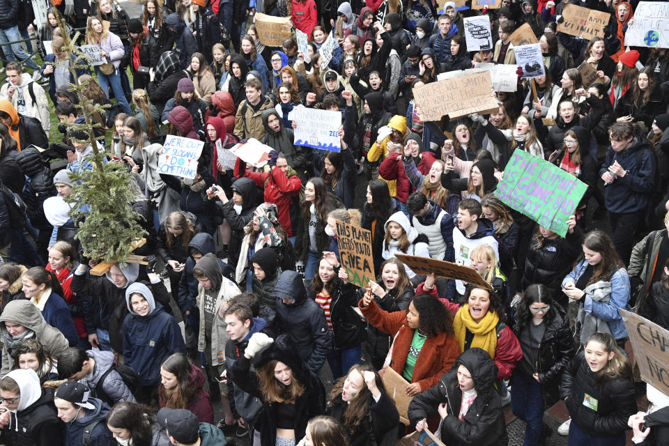Students and others hold placards as they march during a demonstration against climate change in Brussels, Thursday, Jan. 17, 2019. Thousands of students as part of the Youth for Climate movement took time off school Thursday to call for stronger action against climate change. Sign in center reads in Dutch 'shortly everyone will have a house on the sea'. (AP Photo/Geert Vanden Wijngaert)