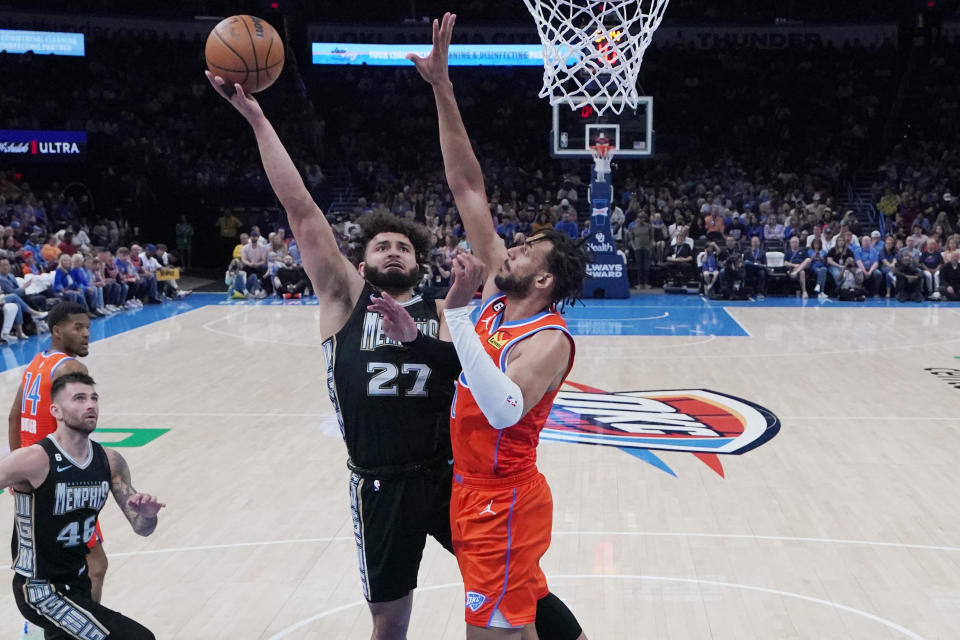 Memphis Grizzlies forward David Roddy (27) shoots as Oklahoma City Thunder center Olivier Sarr, right, defends in the first half of an NBA basketball game Sunday, April 9, 2023, in Oklahoma City. (AP Photo/Sue Ogrocki)