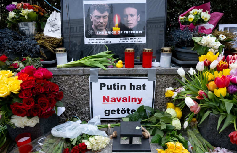 A placard reading "Putin killed Navalny" is placed among Flowers, candles and pictures, laid in tribute to deceased Russian opposition figure Alexei Navalny,  near the Consulate General of the Russian Federation. . Sven Hoppe/dpa