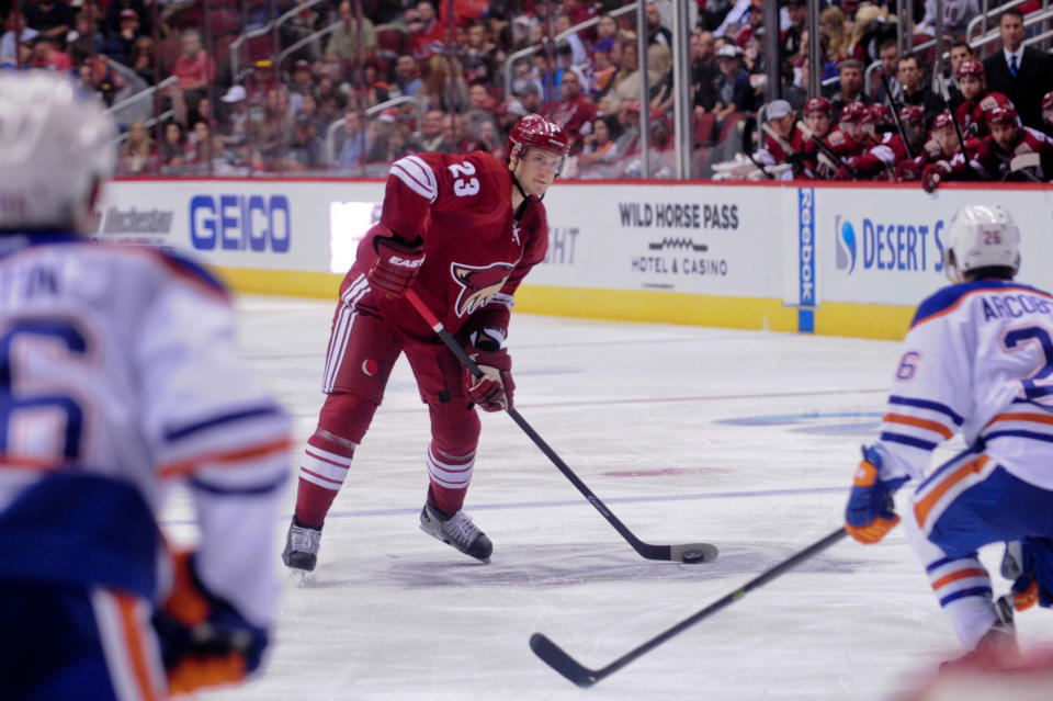 Oct 15, 2014; Glendale, AZ, USA; Arizona Coyotes defenseman Oliver Ekman-Larsson (23) shoots the puck as Edmonton Oilers defenseman Nikita Nikitin (86) and center Mark Arcobello (26) defend during the third period at Gila River Arena. (Matt Kartozian-USA TODAY Sports)