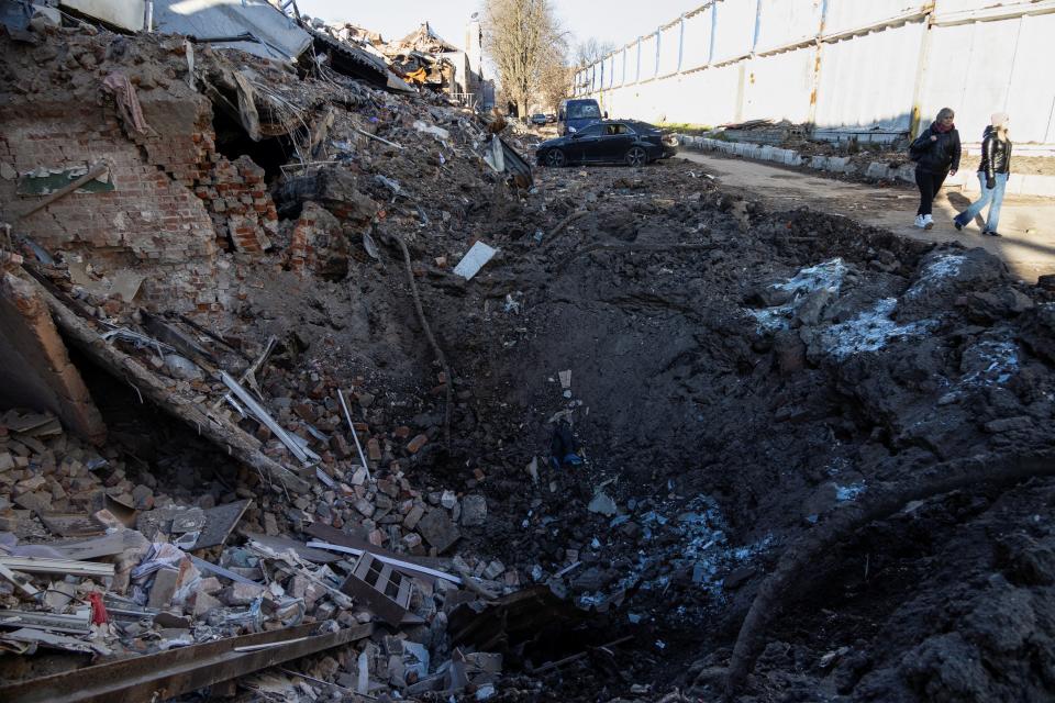 Women walk past a building destroyed by a Russian missile strike, amid Russia's attack of Ukraine, in Kharkiv (REUTERS)