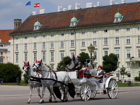 FILE PHOTO: A traditional Fiaker horse-drawn carriage passes the Leopoldine Wing of the Hofburg palace hosting the presidential office in Vienna, Austria May 19, 2016. REUTERS/Heinz-Peter Bader/File Photo