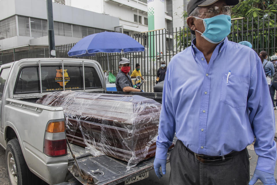 A coffin with the body of a recently deceased person sits in the bed of a pickup truck before burial, outside Teodoro Maldonado Hospital in Guayaquil, Ecuador, Monday, April 6, 2020. Guayaquil, a normally bustling city that has become a hot spot in Latin America as the coronavirus pandemic spreads, also has untold numbers dying of unrelated diseases that can’t be treated because hospitals are overwhelmed. (AP Photo/Luis Perez)