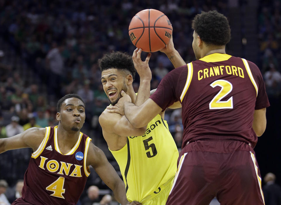 Oregon's Tyler Dorsey, center, drives between Iona's Schadrac Casimir, left, and E.J. Crawford, during the first half of a first-round game in the men's NCAA college basketball tournament Sacramento, Calif. Friday, March 17, 2017. (AP Photo/Rich Pedroncelli)