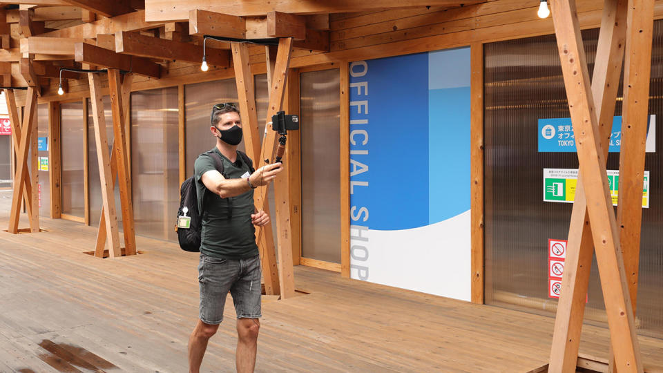 A journalist, pictured here outside an official shop at the Olympic Village in Tokyo.