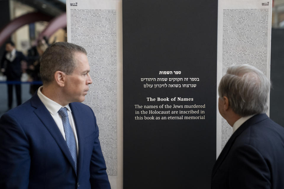 Gilad Erdan, Permanent Representative of Israel to the United Nations, left, and Antonio Guterres, United Nations Secretary General, browse the Yad Vashem Book of Names of Holocaust Victims Exhibit, Thursday, Jan. 26, 2023, at United Nations headquarters. (AP Photo/John Minchillo)