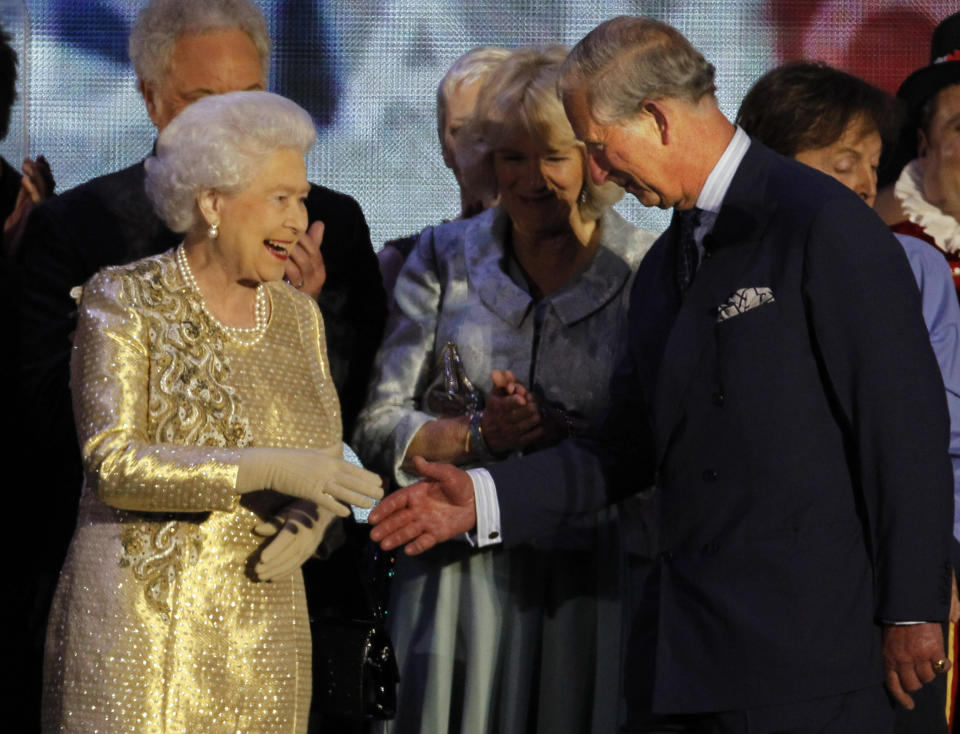 FILE - In this Monday, June 4, 2012 file photo Britain's Queen Elizabeth II shakes the hand of her son Prince Charles at the end of the Queen's Jubilee Concert in front of Buckingham Palace, London. Prince Charles turns 70 Wednesday Nov. 14, 2018, serving as heir to the throne since he was a young child, but his destiny is to be king. (AP Photo/Joel Ryan, File)