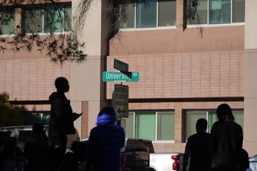 University of Nevada, Las Vegas, students observe police activity after a shooting reported on campus, Wednesday, Dec. 6, 2023, in Las Vegas. (AP Photo/Lucas Peltier)