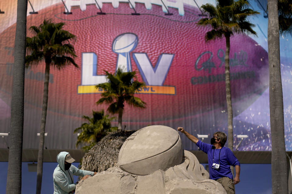 FILE - In this Feb. 4, 2021, file photo, workers sculpt the Lombardi Trophy out of sand outside of Raymond James Stadium ahead of Super Bowl 55 in Tampa, Fla. The city is hosting Sunday's Super Bowl football game between the Tampa Bay Buccaneers and the Kansas City Chiefs. (AP Photo/Charlie Riedel, File)