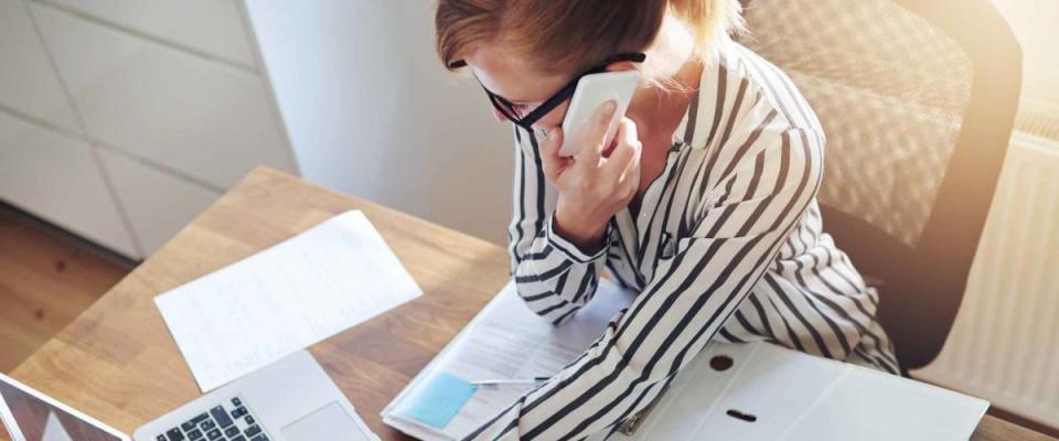 Successful businesswoman with an e-business working from an office at home telemarketing and taking orders over the phone or consulting with clients, high angle view