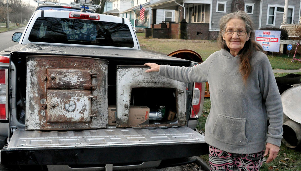 Brenda Deeter stands by the doors to her 1907 coal furnace that had been in her Orrville home. At one time it was converted to a gas furnace. The furnace quit running about two years ago and Deeter has been heating her home with electric space heaters.