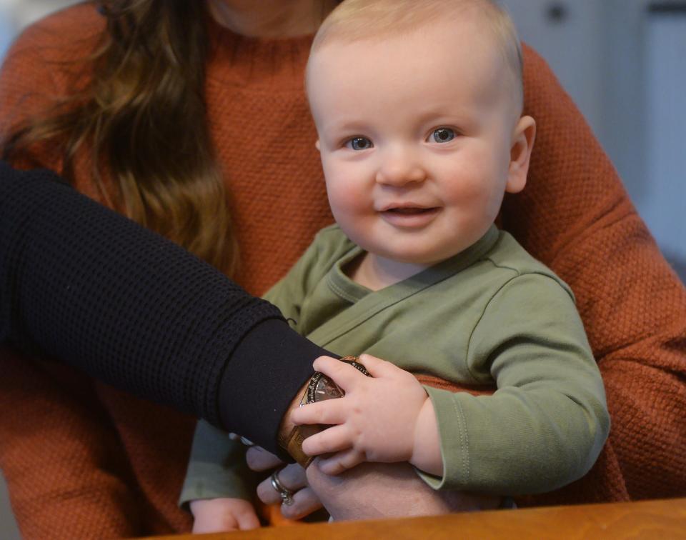 Jon Albert and his wife Stephanie Albert hold their nine-month-old son Evan at home in Fairview Township on Jan. 25, 2024. The family grew through embryonic adoption, with Stephanie carrying and giving birth to Evan.