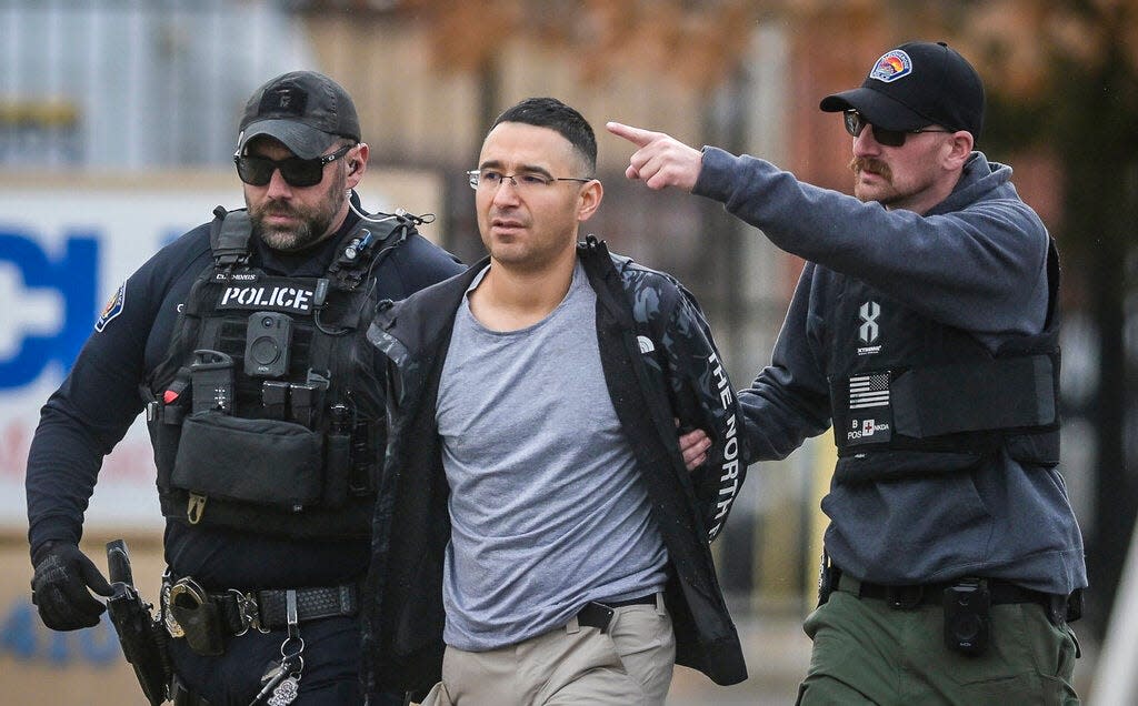 Solomon Pena, center, a Republican candidate for New Mexico House District 14, is taken into custody by Albuquerque Police officers, Monday, Jan. 16, 2023, in southwest Albuquerque, N.M. Pena was arrested in connection with a recent series of drive-by shootings targeting Democratic lawmakers in New Mexico.