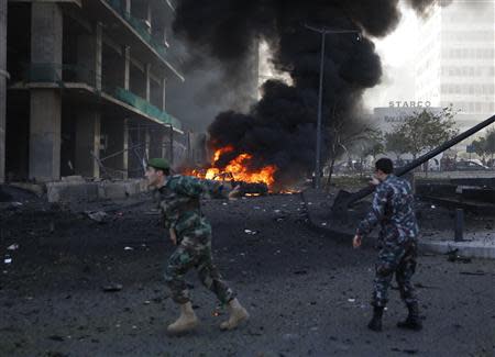 A Lebanese army soldier gestures as he runs near the site of the explosion in Beirut's downtown area December 27, 2013. REUTERS/Steve Crisp