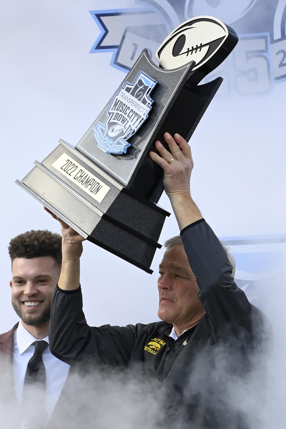 Iowa head coach Kirk Ferentz hold up the trophy after Iowa beat Kentucky 21-0 in the Music City Bowl NCAA college football game Saturday, Dec. 31, 2022, in Nashville, Tenn. (AP Photo/Mark Zaleski)