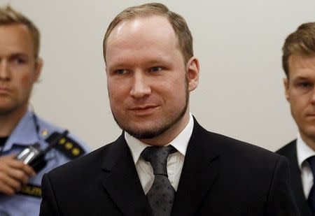 Norwegian mass killer Anders Behring Breivik smiles as he arrives at the court room in Oslo Courthouse in this August 24, 2012 file photo. REUTERS/Stoyan Nenov/Files