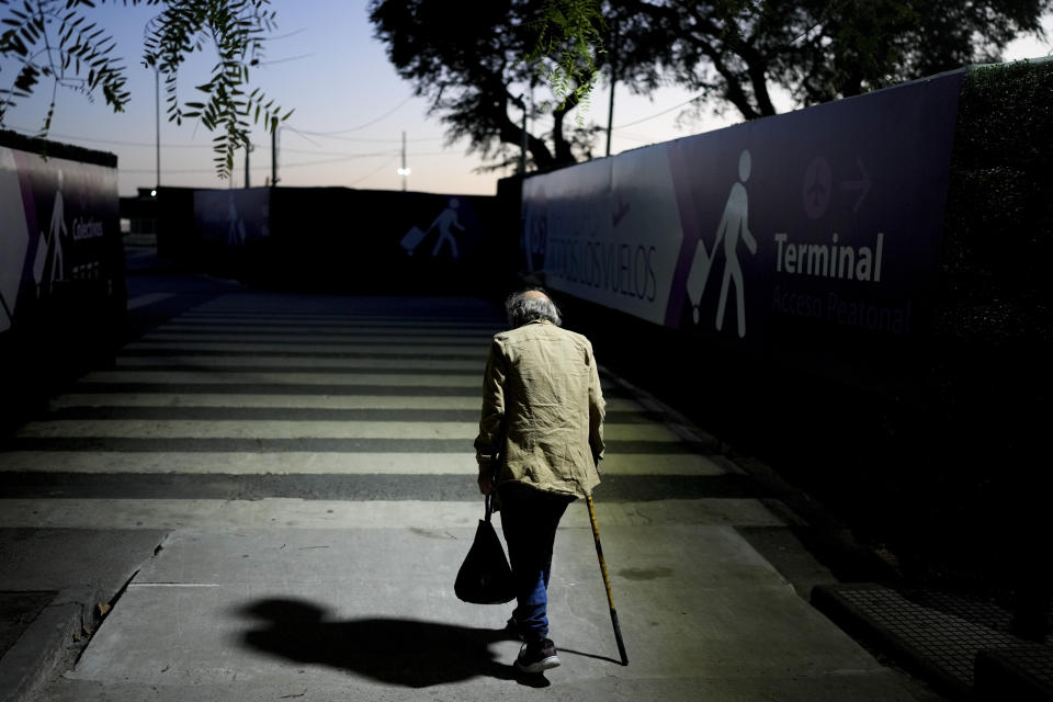 Angel Gomez exits the Jorge Newbery international airport, commonly known as Aeroparque, in Buenos Aires, Argentina, Thursday, April 6, 2023. Gomez, who is homeless, has made Aeroparque his home where he sleeps each evening. During the day Gomez begs for money at traffic lights and eats in soup kitchens. (AP Photo/Natacha Pisarenko)