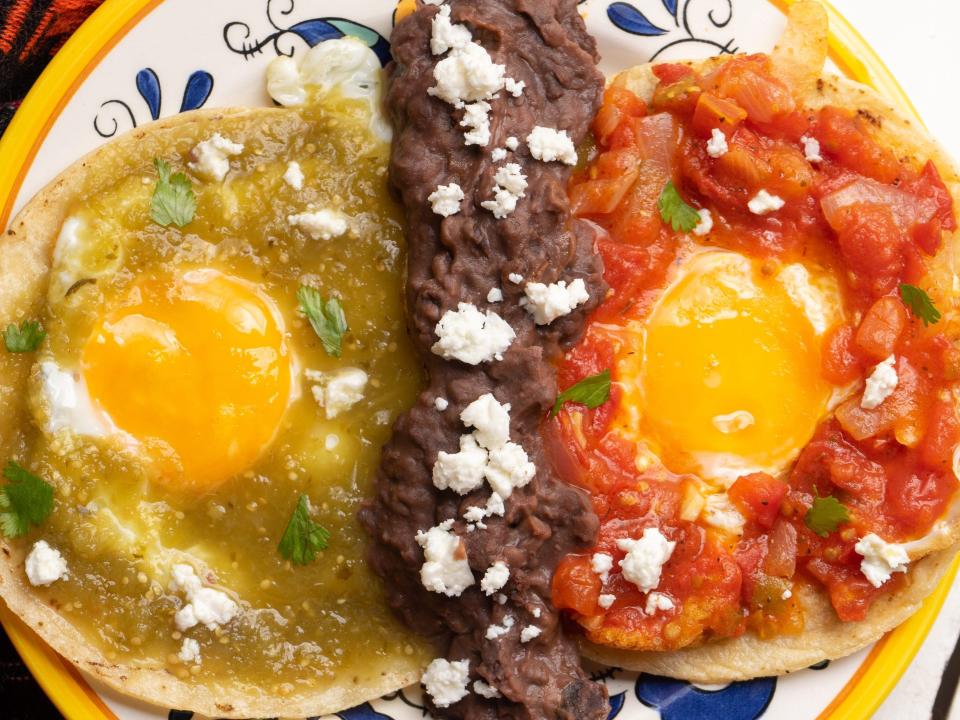 Traditional mexican fried eggs with green and red sauce also called "divorciados" on white background