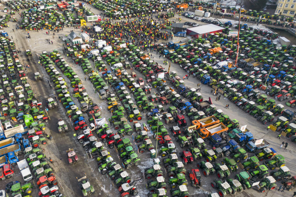 Farmers with hundreds of tractors take part in a protest rally in Augsburg, southern Germany, Wednesday, Jan. 10, 2024. In response to the federal government's austerity plans, the farmers' association has called for a week of action with rallies. It is to culminate in a large demonstration in the German capital Berlin on January 15. (Peter Kneffel/dpa via AP)