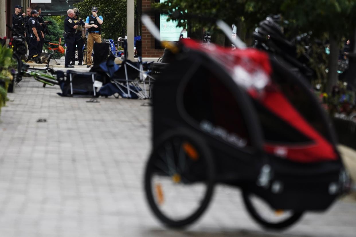 Law enforcement search in downtown Highland Park, a Chicago suburb, after a mass shooting at the Highland Park Fourth of July parade, Monday, July 4, 2022. 