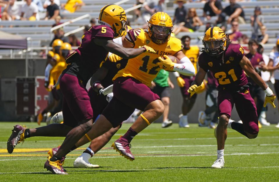 ASU tight end Jalin Conyers (12) carries Maroon defenders to a first down on a reception during the Spring Game at Sun Devil Stadium in Tempe on April 15, 2023.