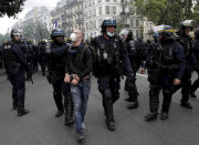 Police detain a protestor during a demonstration in Paris, France, Saturday, July 31, 2021. Demonstrators gathered in several cities in France on Saturday to protest against the COVID-19 pass, which grants vaccinated individuals greater ease of access to venues. (AP Photo/Adrienne Surprenant)