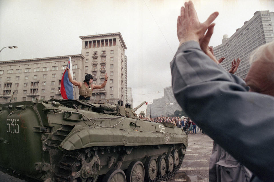 FILE - In this Wednesday, Aug. 21, 1991 file photo, a crowd greet a jubilant tank officer with the Russian national flag in the street of Moscow amid reports that the coup has failed, in Russia. When a group of top Communist officials ousted Soviet leader Mikhail Gorbachev 30 years ago and flooded Moscow with tanks, the world held its breath, fearing a rollback on liberal reforms and a return to the Cold War confrontation. But the August 1991 coup collapsed in just three days, precipitating the breakup of the Soviet Union that plotters said they were trying to prevent. (AP Photo/Czarek Sokolowski, File)
