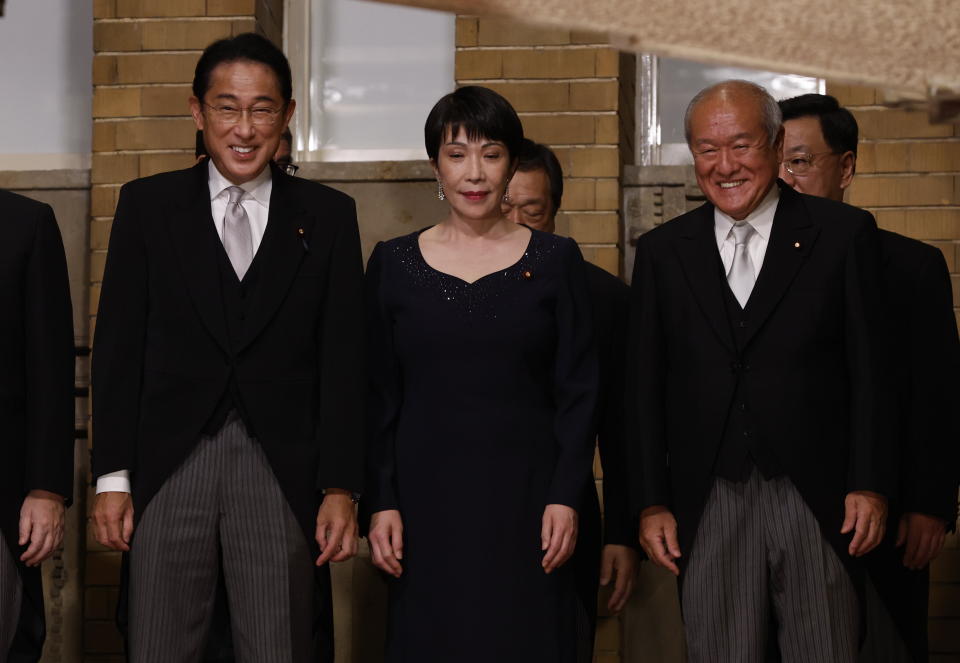 Japan's Prime Minister Fumio Kishida, left, Minister in Charge of Economic Security Sanae Takaichi, center, Finance Minister Shunichi Suzuki and other ministers prepare for a photo session at Kishida's residence Wednesday, Aug. 10, 2022, in Tokyo. (Issei Kato/Pool Photo via AP)