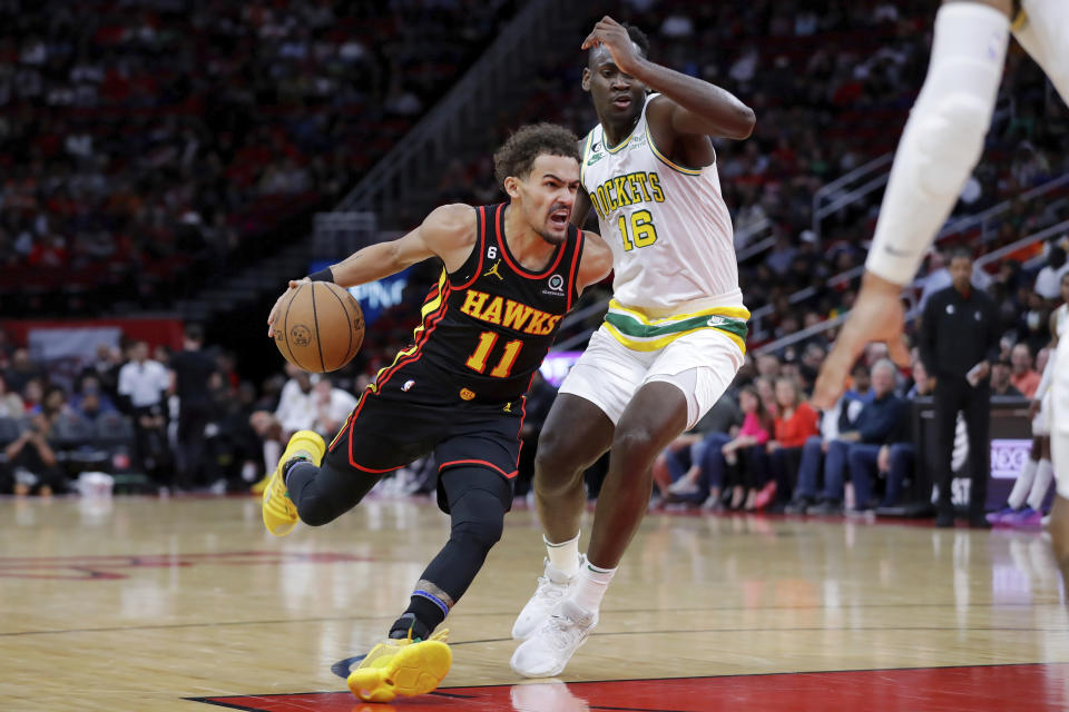 Atlanta Hawks guard Trae Young (11) drives around Houston Rockets forward Usman Garuba (16) during the first half of an NBA basketball game Friday, Nov. 25, 2022, in Houston. (AP Photo/Michael Wyke)