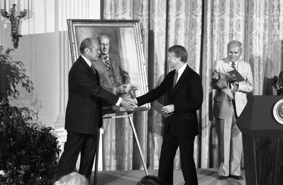 FILE - President Jimmy Carter shakes hands with former President Gerald Ford at the White House in Washington, on May 24, 1978, during a ceremony at which a portrait of Ford was unveiled. The portrait, which will hang at the White House rests on an easel between them. Former President Barack Obama's presidential portrait will be unveiled at the White House in a Sept. 7, 2022, ceremony hosted by President Joe Biden. (AP Photo/File)