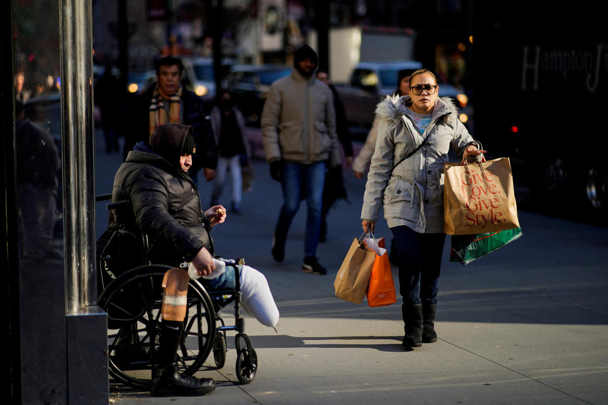 A woman carries shopping bags during the holiday season in New York City, U.S., December 21, 2022. REUTERS/Eduardo Munoz
