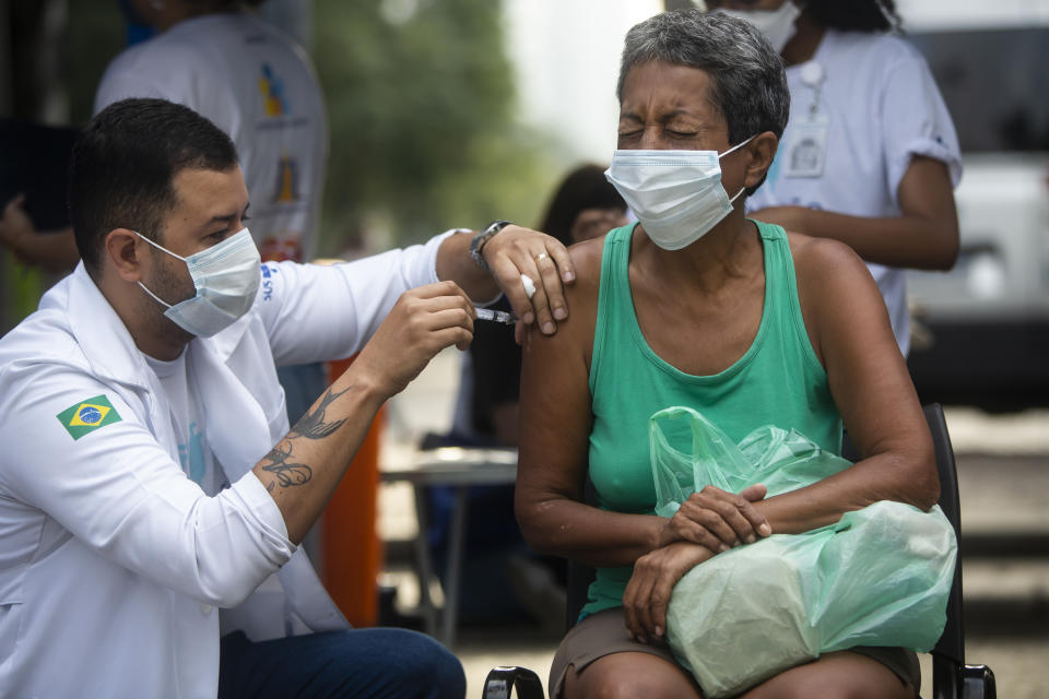 A woman gets a shot of the AstraZeneca vaccine for COVID-19 at a public square during a vaccination program for the homeless in Rio de Janeiro, Brazil, Thursday, May 27, 2021. (AP Photo/Bruna Prado)