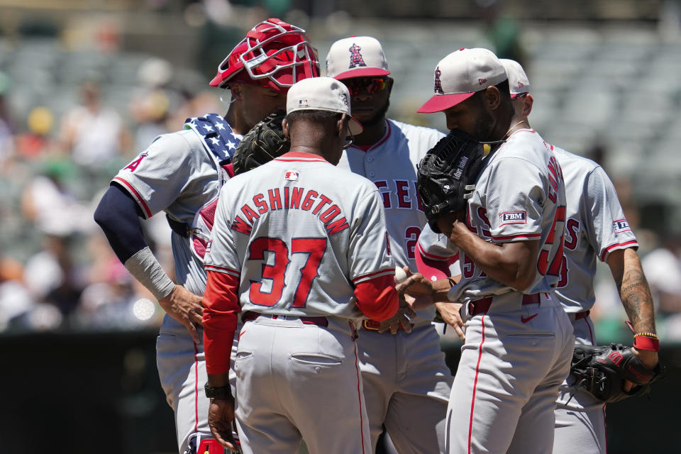 Los Angeles Angels pitcher Roansy Contreras, second from right, hands the ball over to manager Ron Washington (37) as he exits during the third inning of a baseball game against the Oakland Athletics, Thursday, July 4, 2024, in Oakland, Calif. (AP Photo/Godofredo A. Vásquez)