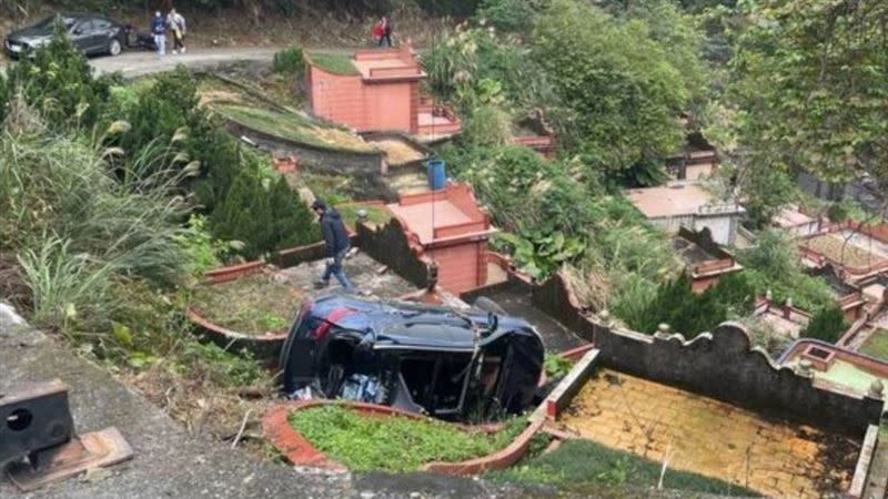 車輛滑落邊坡卡在墳墓間。（圖／翻攝畫面）