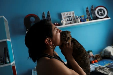 Miriam Gutierrez plays with her cat at her home in Torrejon de ArdozA