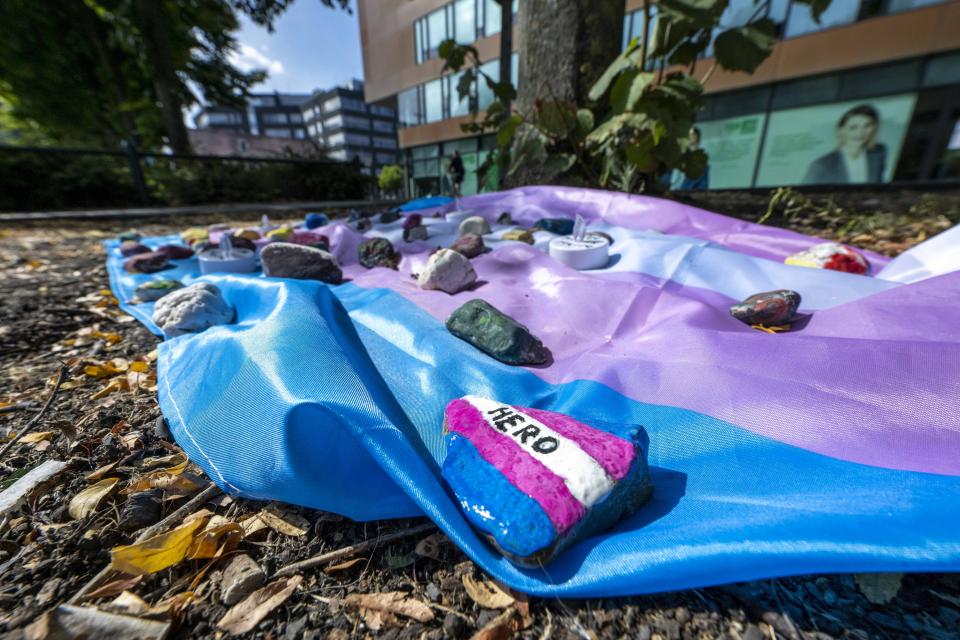 People have laid out a flag weighted down with painted stones in Muenster, Germany, Aug. 30, 2022. Prosecutors in Germany say a 25-year-old man has died from injuries suffered in an attack at a gay pride event in the western city of Muenster. (David Inderlied/dpa via AP)