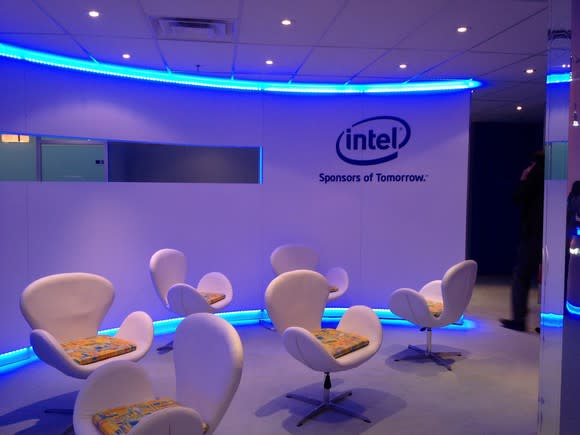 Room with Intel logo on wall and chairs with neon light trim.